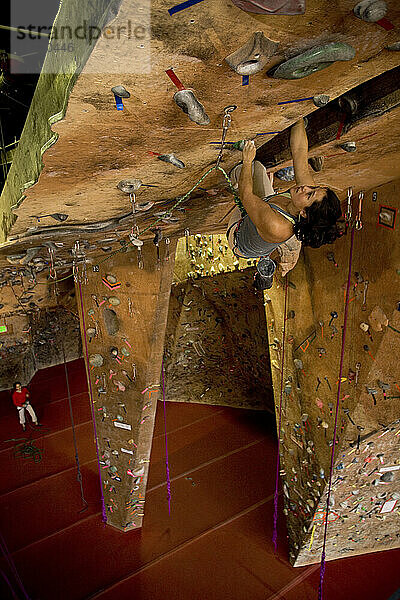 Eine Klettererin klettert in einer Indoor-Kletterhalle.