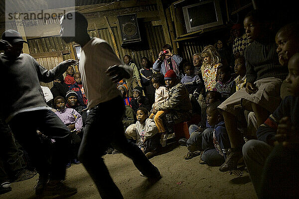 Touristen beobachten lokale Tänze während einer Township-Tour durch Imizamo Yethu Township  Hout Bay  Südafrika.