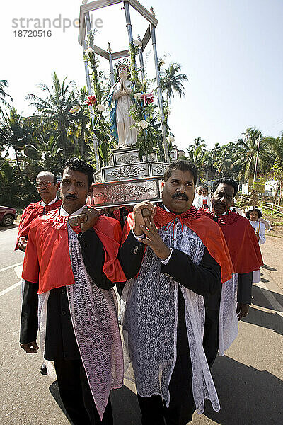 Goa-Priester tragen Unsere Liebe Frau auf einem silbernen Streitwagen zur St.-Alex-Kirche. Goa  Indien.