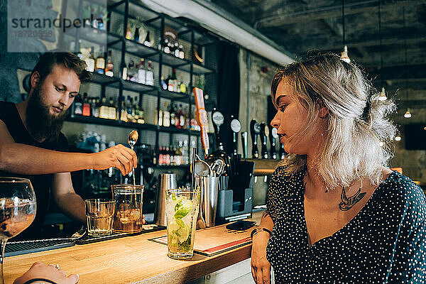 Mädchen und Barmann in einer Cocktailbar.