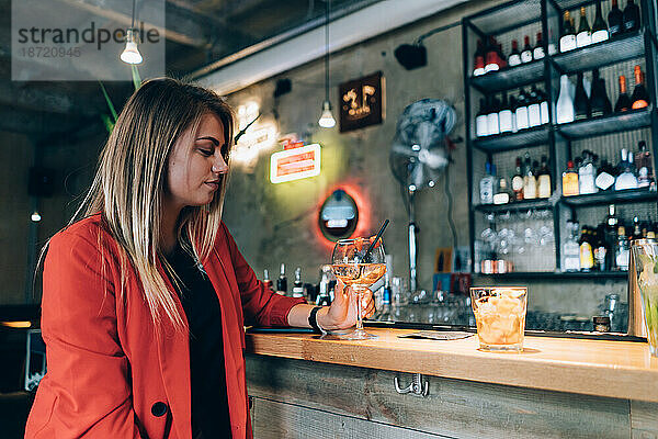 Blondes Mädchen in einer Cocktailbar.