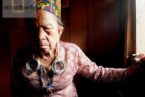 Eine ältere Frau trägt die traditionellen Ohrringe ihrer Vorfahren.