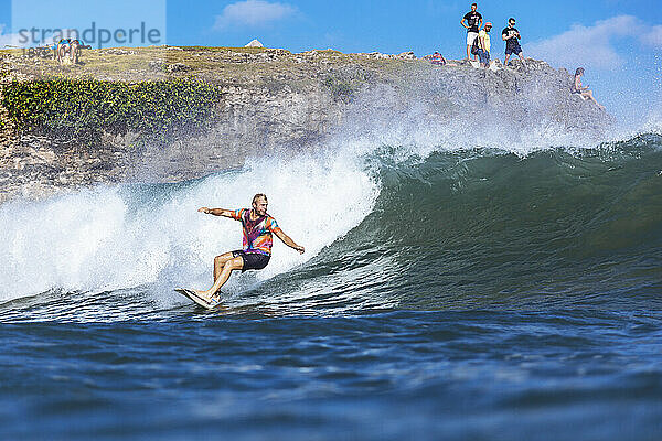 Surfer reitet auf einer Welle im Meer  Jimbaran  Bali  Indonesien