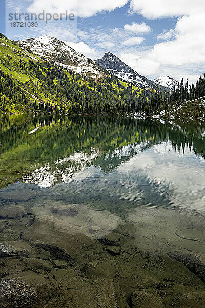 Malerischer Blick auf den Alpensee in den Bergen mit blauem Himmel in Kanada.