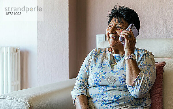 Lateinamerikanische Seniorin spricht mit ihren Freunden auf dem Smartphone