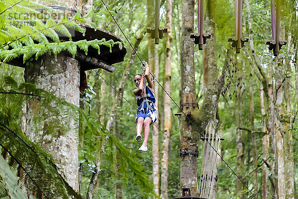 Ein Mädchen steigt eine Seilrutsche in einem Treetop Adventure Park auf Bali  Indonesien  hinab