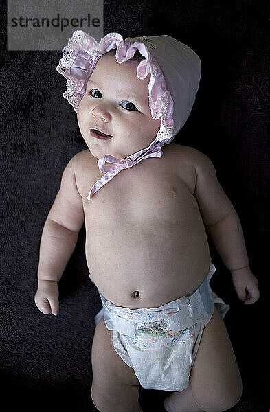 Porträt eines kleinen Mädchens mit rosa Mütze.