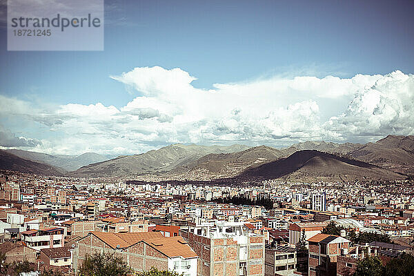 Heller  sonniger Blick über die Stadt Cusco und die Berge und Wolken