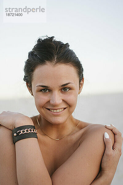 Nahaufnahmeporträt einer lächelnden Frau am Strand