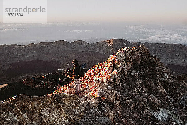 Ein männlicher Wanderer beobachtet den Sonnenaufgang vom Gipfel des El Teide