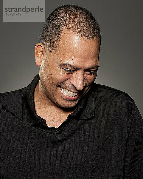 Studioporträt eines 47-jährigen afroamerikanischen Mannes  der lacht.