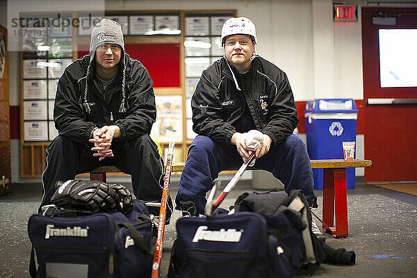 Zwei Hockeyspieler warten im Wärmeraum einer Hockeyarena.