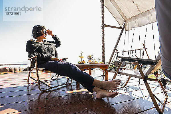schöne Frau entspannt auf Holzdeck über Chiang Rai