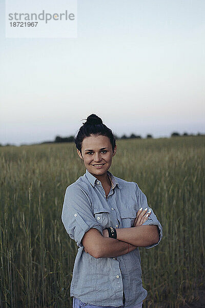 Eine Frau steht in einem Weizenfeld