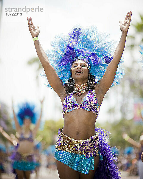 Eine brasilianische Tänzerin tritt bei einer Parade in Santa Barbara auf. Die Parade umfasst extravagante Festwagen und Kostüme.