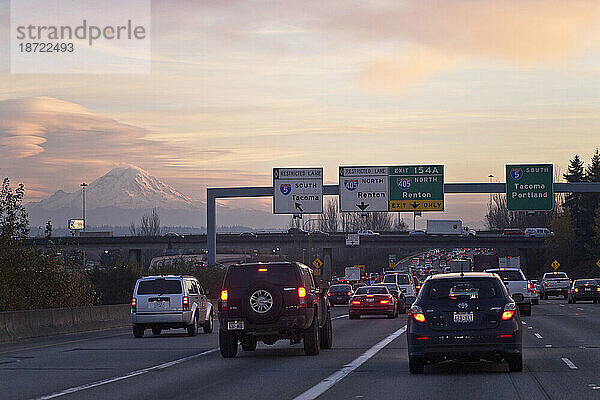 Starker Verkehr bringt die Interstate 5 zum Stillstand  während im Hintergrund der Mount Rainier bei Sonnenuntergang in Seattle  Washington  auftaucht.