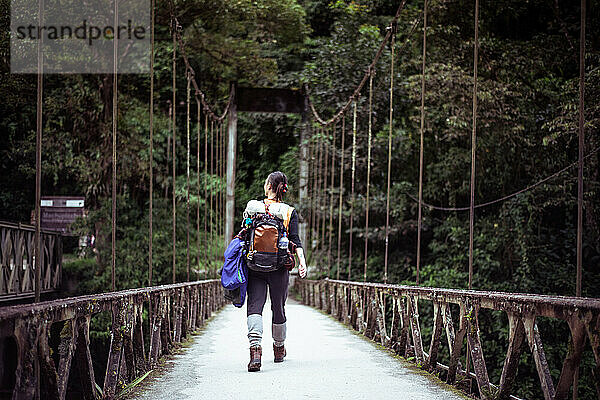 Androgyne Frau geht über Drahtbrücke nach Machu Picchu