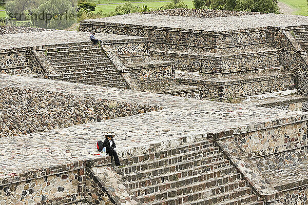 Menschen sitzen allein auf der Spitze von Tempeln in der präkolumbianischen archäologischen Stätte von Teotihuacan  Bundesstaat Mexiko  Mexiko.