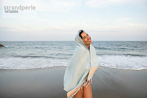 Latina-Frau vergnügt sich mit Handtuch am Strand