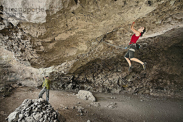 Eine Frau mittleren Alters beim Klettern in der Actopan-Höhle  Hidalgo  Mexiko.