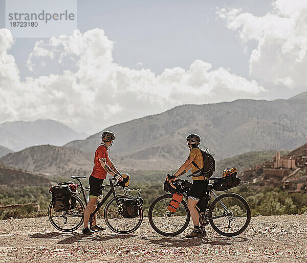 Ein paar Radfahrer genießen den Blick auf das Atlasgebirge in Marokko