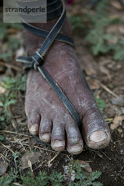 Eine Nahaufnahme der abgenutzten Füße eines Tarahumara-Indianers  der Huaraches trägt.