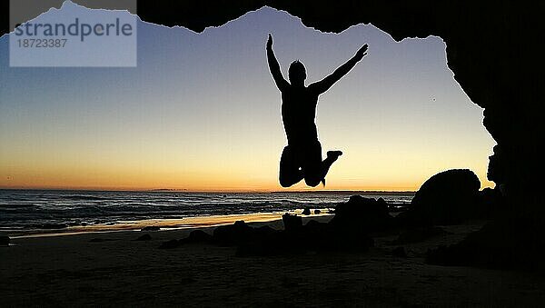 Silhouette eines Mannes  der am Strand springt