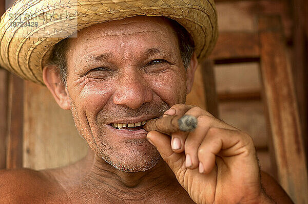 Ein kubanischer Tabakbauer raucht Zigarre auf seiner Veranda.