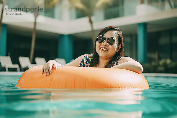 Happy asian plus size woman in a pool with ring float. Generative AI.