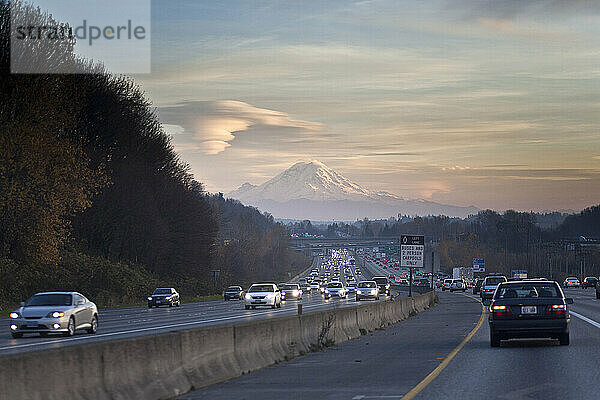 Starker Verkehr bringt die Interstate 5 zum Stillstand  während im Hintergrund der Mount Rainier bei Sonnenuntergang in Seattle  Washington  auftaucht.