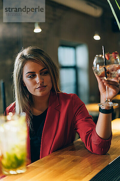 Blondes Mädchen schaut zu ihrer Cocktailbar.