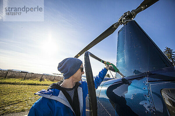 Hubschrauberpilot betankt seinen auf dem Hubschrauberlandeplatz geparkten Hubschrauber.