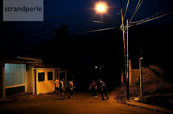 Junge Männer spielen nachts Fußball auf der Straße in Tovar  Venezuela.