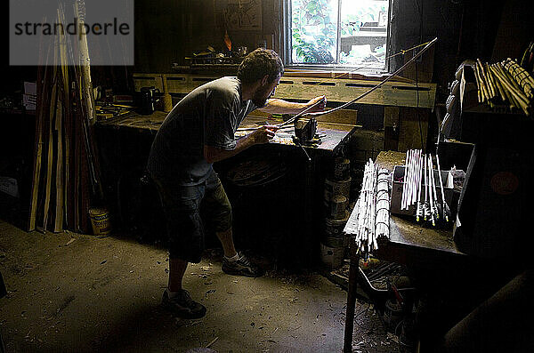 Ein Handwerker arbeitet in seiner Heimwerkstatt in Lake Pleasant  Massachusetts  an einem handgefertigten Bogen.