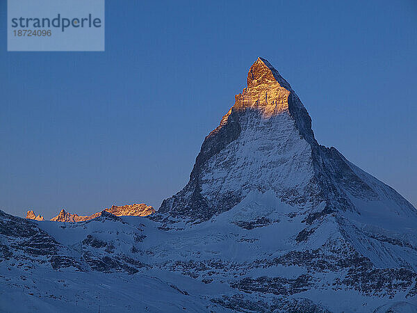 Das Matterhorn badet an einem klaren Wintermorgen im ersten Sonnenlicht. (Alpenglühen)