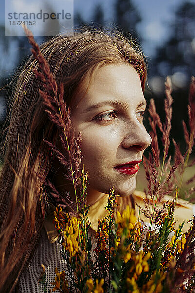 Porträt einer schönen Frau mit einem Strauß wilder Blumen