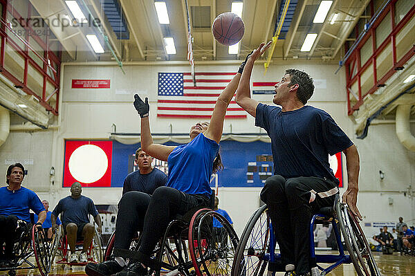 Rollstuhlbasketballspieler kämpfen während eines Spiels um den Ball.