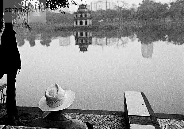 Ein Mann starrt auf den Hoan-Kiem-See in Hanoi  Vietnam.