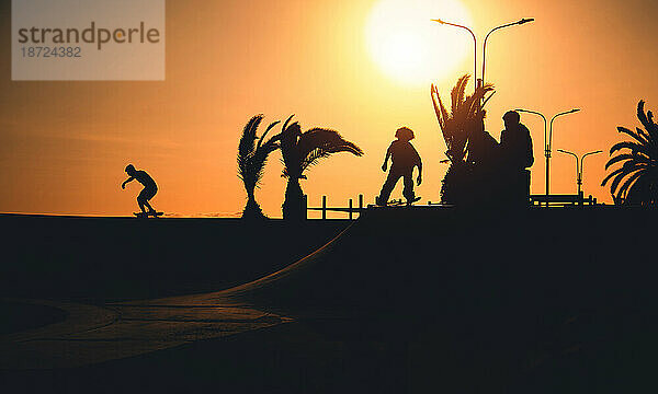 Eine Gruppe Teenager auf Skateboard im Sommer  Silhouette nicht wiederzuerkennen.