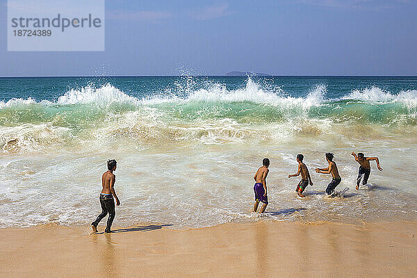 Junge Jungen spielen in der Nähe des Ozeans.