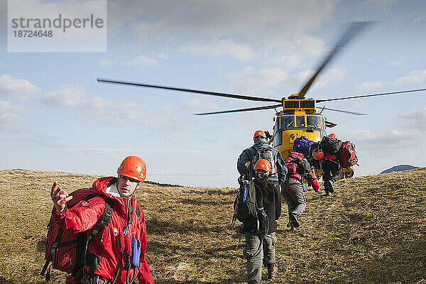 Mitglieder des Langdale/Ambleside Mountain Rescue-Teams führen gerettete Wanderer in Sicherheit  zu einem wartenden RAF-Sea-King-Hubschrauber  nachdem sie aus Dungeon Ghyll gerettet worden waren