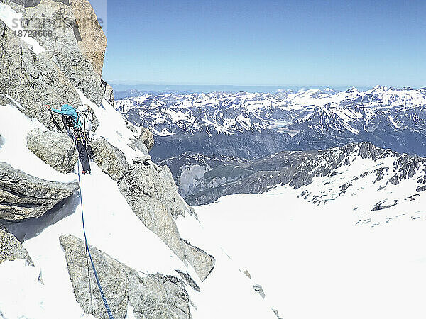 Eine Alpinistin konzentriert sich in steilem  ungeschütztem Gelände