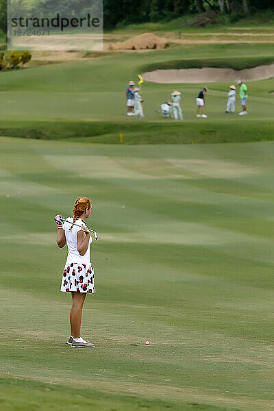 Seitenansicht einer jungen Frau beim Golfspielen