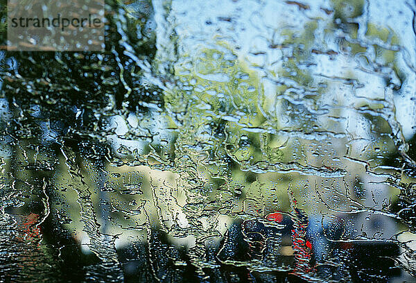 Blick durch das Wasser auf eine Glaswindschutzscheibe in der Autowaschanlage.