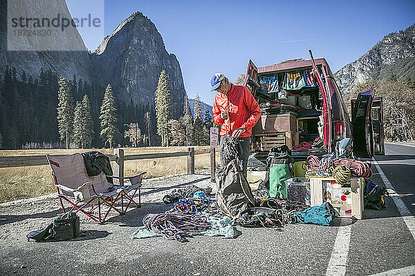 Ein Kletterer sortiert seine Ausrüstung hinter seinem Lieferwagen auf den Wiesen von El Capitan