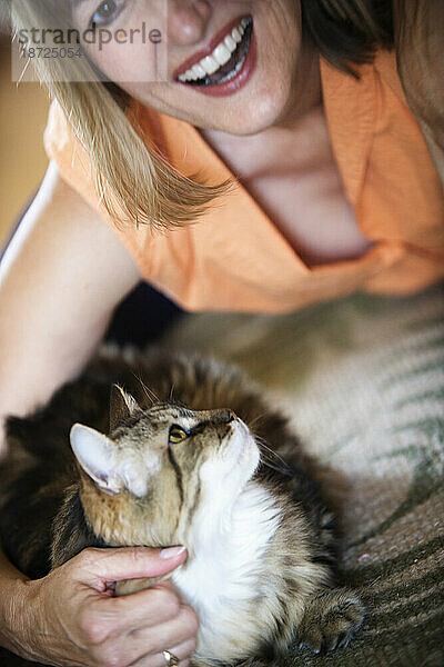 Eine Frau hält liebevoll ihre Katze.