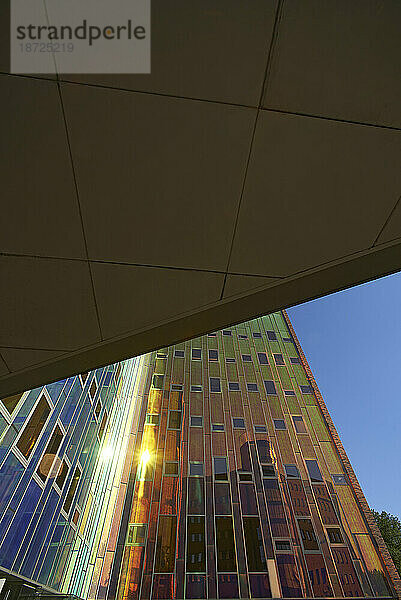 Erstaunlich farbenfrohe  reflektierende Fassade eines modernen Bürogebäudes in der Sonne