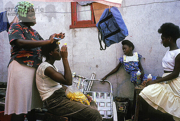 Frauen flechten ihre Haare in Kingston  Jamaika