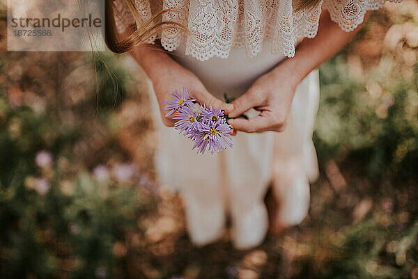 Mädchen hält lila Blumen