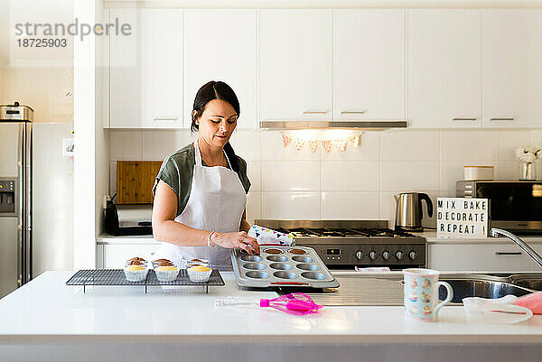 Eine Frau backt Cupcakes in ihrer Küche